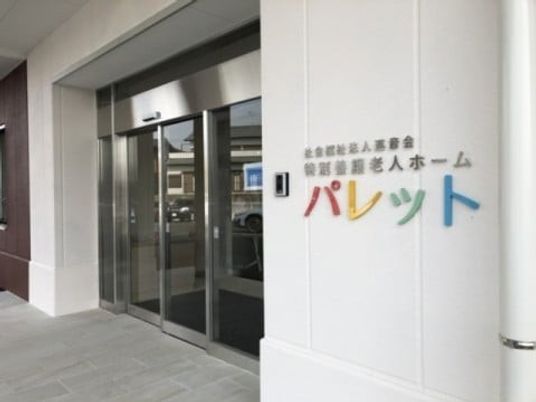 施設入口の看板と自動扉のある外観  