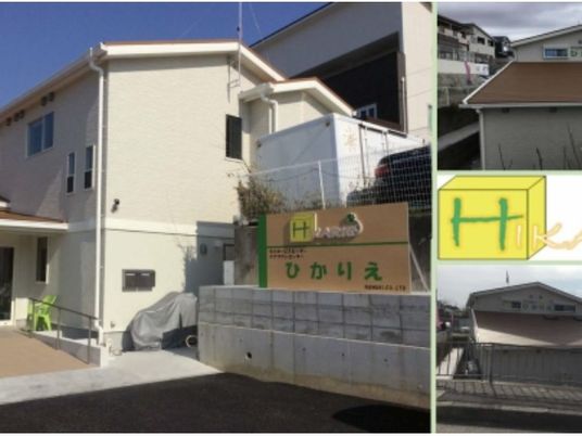施設外観の看板前  