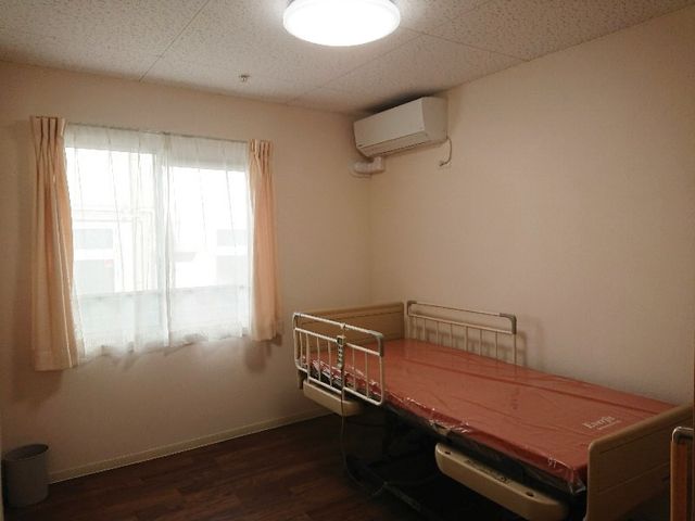 明るい窓辺の居室 居室 自然光がたっぷり入る居室は、清潔で心地よい空間です。ベッドが設置されています。