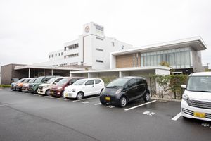 白い建物と駐車場外観