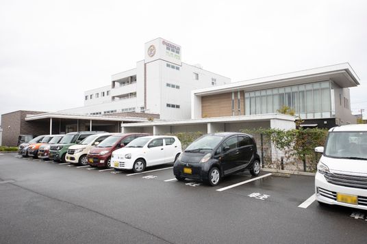 白い建物と駐車場外観