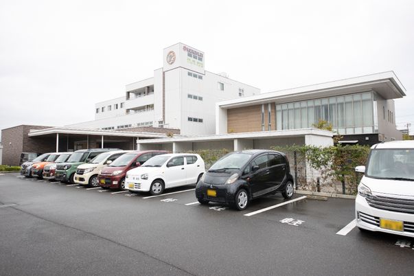 白い建物と駐車場外観