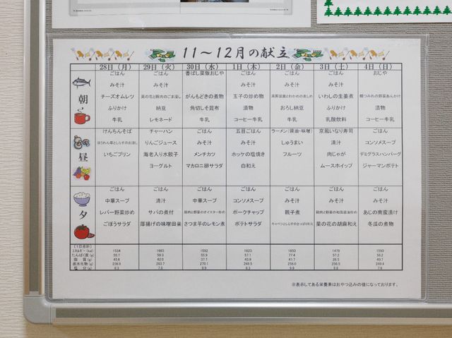 掲示物の詳細なスケジュール 献立表 スケジュールが細かく記載された掲示板を目の前に、日々の活動が充実していることが伺えます。