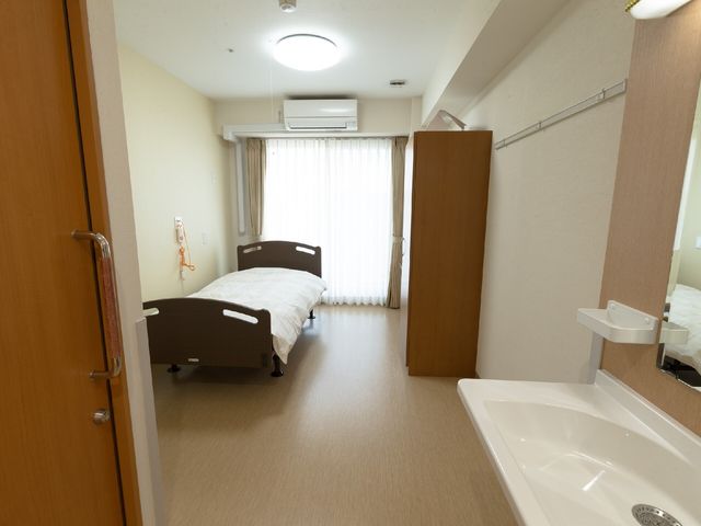 居室の明るい空間 居室 二つのベッドが配された居室は、適度なプライバシーとゆとりを確保しています。日々の生活に必要な設備も整っており、安心してお過ごしいただけます。