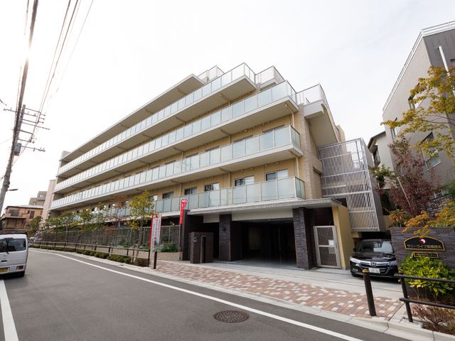清潔感のある建物正面 外観 モダンなデザインの建物前で、快適な職場環境が期待できます。美しい緑が彩る街並みと調和しています。