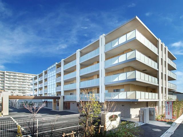 介護施設の外観 外観   青空の下に、明るい色合いの建物がゆったりと建っています。バルコニーが並ぶ落ち着いた佇まいで、働く場所の雰囲気が伝わります。