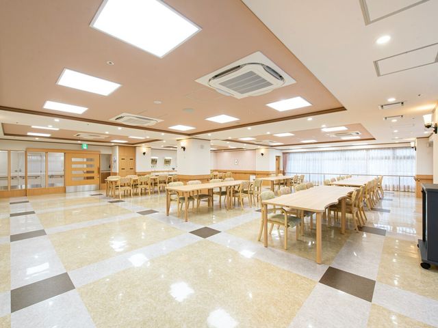広々とした明るい食堂 食堂 床が光沢のあるタイルで覆われた広々とした食堂です。木製のテーブルや椅子が並び、安らぎながら食事ができる空間が確保されています。