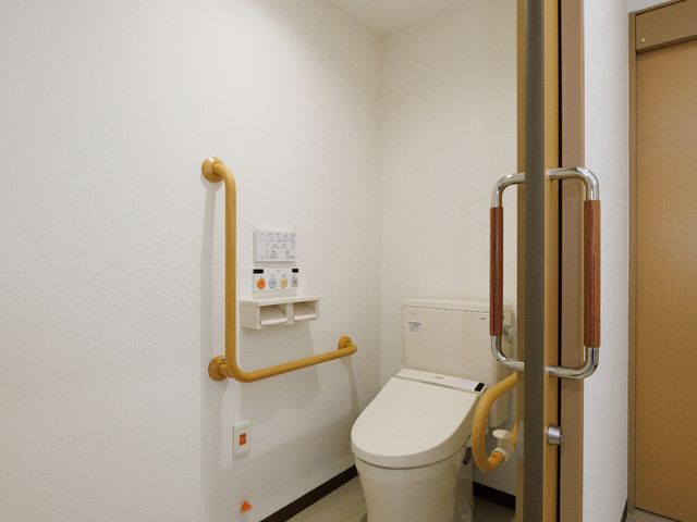 バリアフリー対応トイレ トイレ 手すり付きの清潔なトイレです。安全と快適な利用を支える設計が練られています。