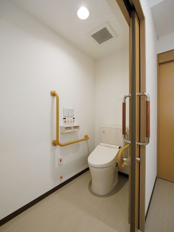 バリアフリー対応トイレ トイレ 手すり付きの清潔なトイレです。安全と快適な利用を支える設計が練られています。