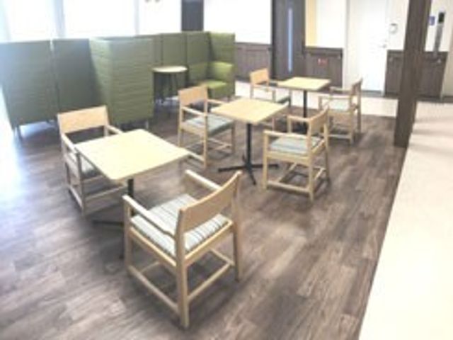 落ち着いた雰囲気の部屋 ラウンジ 自然光が差し込む柔らかな雰囲気のある空間です。机と椅子が配置され、休憩に最適です。