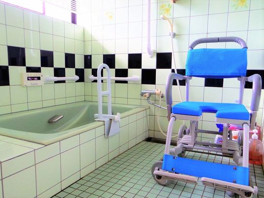 手すりが取り付けられている施設内の浴室の様子。タイル仕様の壁が映っている写真