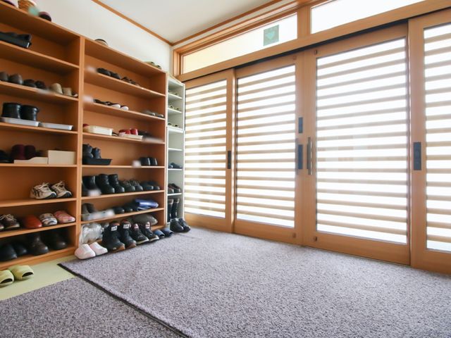 整理された靴箱のエントランス 玄関 ゆとりある空間のエントランスでは、靴の収納に便利な大きな靴箱が設置され、日常の出入りが快適です。
