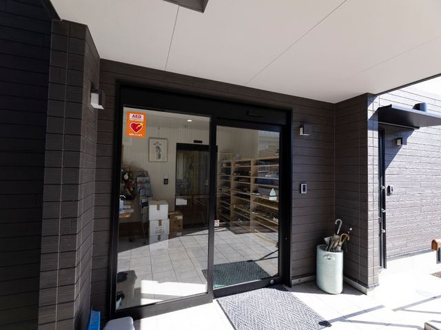 エントランスの開放感ある扉 玄関 快適な出入りができるエントランスです。安心のAED設置も完備されており、万全なサポート体制が整っています。