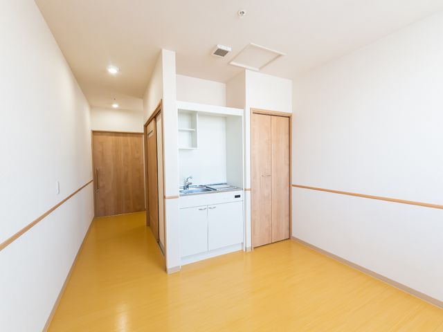 明るい洋室のキッチンコーナー 居室 ゆったりとした空間の明るい部屋です。必要な機能を備えたキッチンが設置されており、心地よい生活をサポートします。