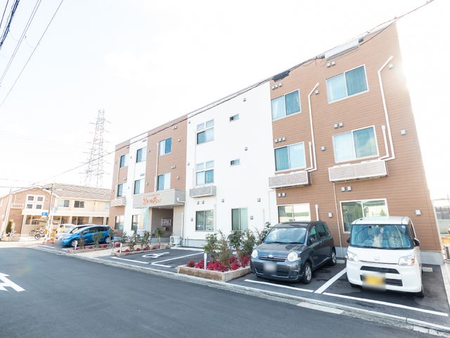 清潔感のある建物の外観 玄関 きれいに整備された建物の前面です。広々とした駐車スペースがあり、訪れる方々の利便性を考慮しています。