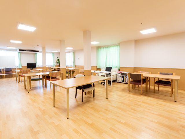 多目的スペースの快適な室内 共有スペース ゆったりとした多目的室は木の温もり溢れる床や明るく大きな窓の存在が、心地よい仕事環境を約束します。ゆとりのあるデスクや椅子も完備され、快適にお過ごしいただけます。