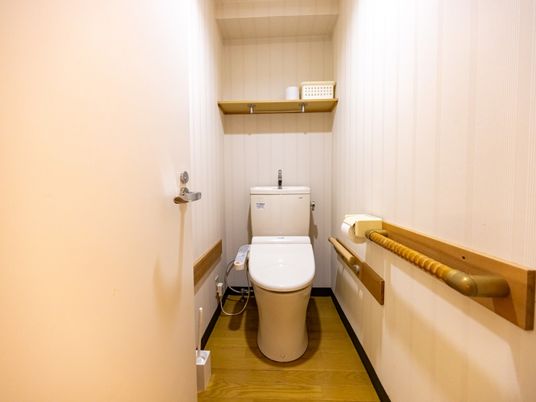 手すり付きの収納棚付きトイレ