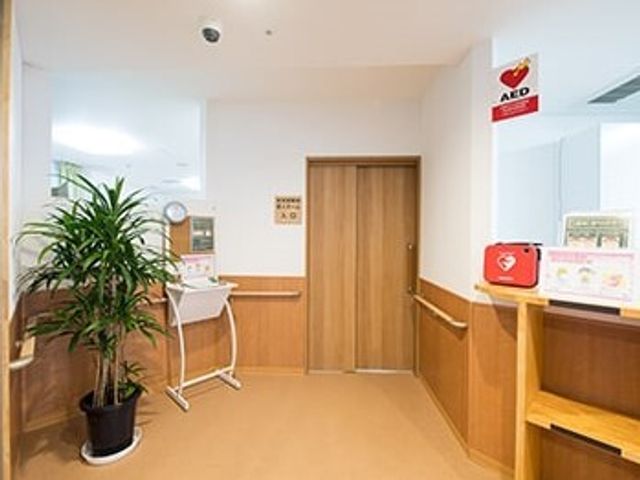 清潔な廊下の一角 エントランス 親しみやすい植物が置かれた角にはAEDを配備し、安全面にも配慮がされています。スタッフの方々が常に快適な環境を整え、利用者様のケアにあたっています。