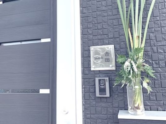 花と表札の玄関外観  