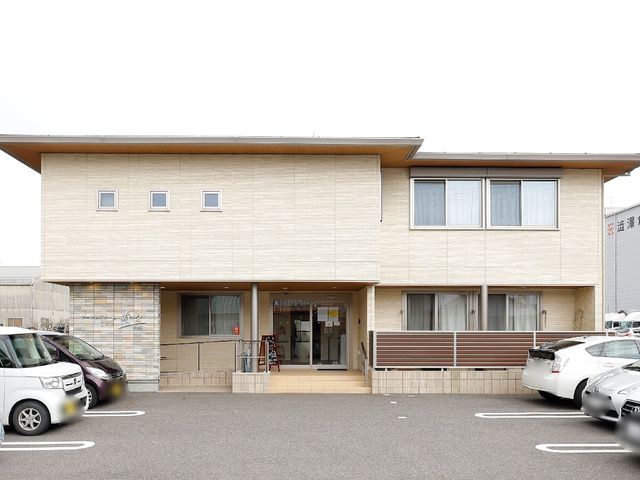 清潔感ある建物外観 外観 広々とした駐車場が整備された施設前は、訪問者を温かく迎え入れます。明るく落ち着いた色合いの建物が印象的です。