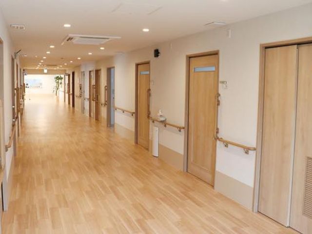 長い木製床の廊下 廊下 木の温もりを感じる広々とした廊下です。手すりが設置されており、移動時も安心できます。