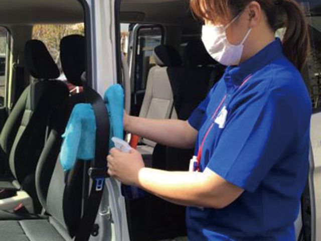 車内清掃中のスタッフ スタッフイメージ スタッフが車の清掃を行う様子です。きれいな車で快適な送迎をサポートします。