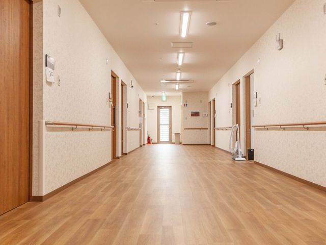 明るい廊下の様子 廊下 手すりが設置されたゆったりとした通路です。清掃が行き届いており、清潔感が保たれています。