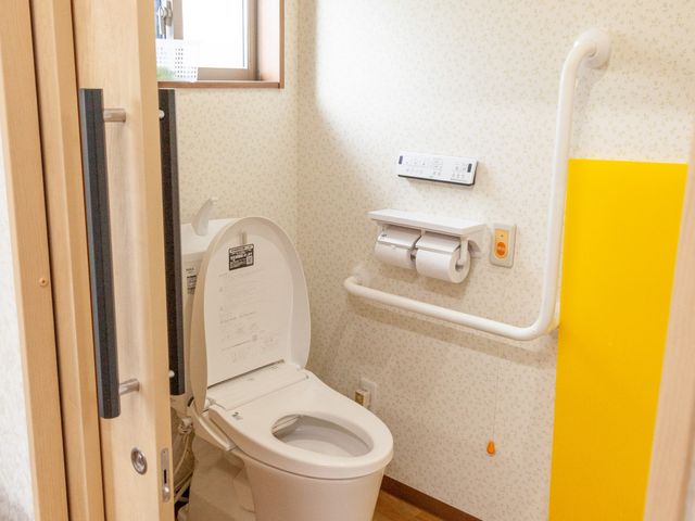 バリアフリートイレ設備 トイレ 手すり付きの温水洗浄便座が完備された清潔なトイレ空間です。安全かつ快適にお使いいただける設計になっております。