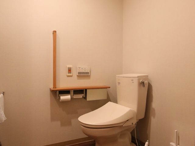 清潔なトイレスペース トイレ 手すり付きのトイレはバリアフリー設計で、安心してお使いいただけます。清潔さが保たれた空間がここでも感じられます。