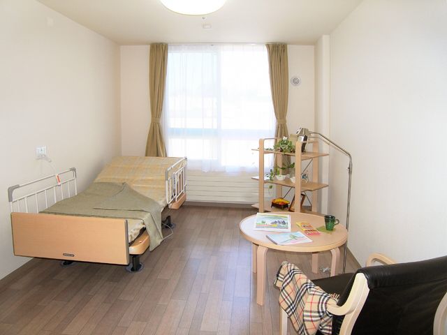 清潔な居室の一例 個室 清潔感あふれる居室で、日々の生活を安心してお過ごしいただけます。窓から見える自然光がお部屋を明るく照らしています。