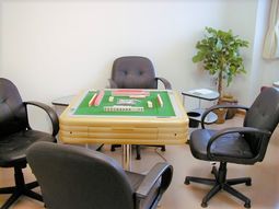 椅子とマージャン卓のある部屋
