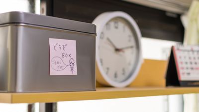 時計と書類箱のある棚