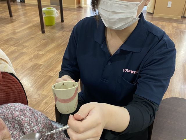 介護の手助け 居室 居室 スタッフが優しい手つきで食事の介助をしています。明るい空間でのサポートが心地よい時間を提供しています。