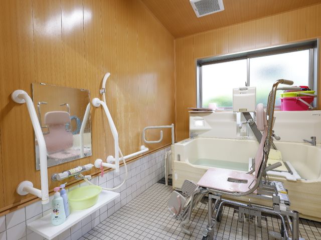 バリアフリーの浴室設備 浴室 手すりや椅子が備わった、安心の入浴スペースです。窓からは自然光が差し込み、清潔感あふれる空間を提供しています。