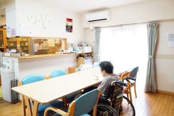 車椅子の方がいる明るい食堂