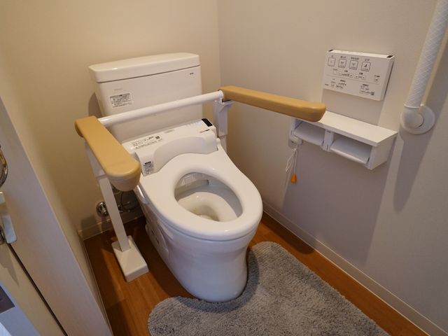 バリアフリートイレ設備 トイレ 安全に配慮された手すり付きの清潔なトイレスペースです。利用しやすい設計で快適な毎日をサポートします。