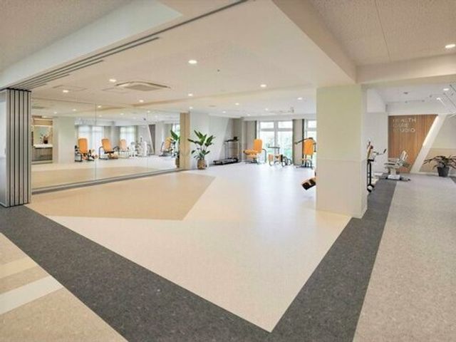 広々とした機能訓練室 ヘルスケアスタジオ 開放的な空間で、バランスボールやトレーニングマシンを使い、体を動かすことができます。健康維持をサポートする器具が整っており、安全に配慮された設計です。