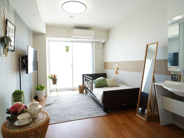 快適な居室の一角 居室 開放的な窓と多彩な植物が彩る居室では、ゆったりとした時間をお過ごしいただけます。デザインと機能性を兼ね備えた洗面台もご用意しております。