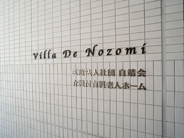 施設の名前が刻まれた看板 ロゴ モダンなデザインの看板が静かな雰囲気を演出し、訪れる人を温かく迎えます。心機一転、新しい職場でのスタートをご一緒しましょう。