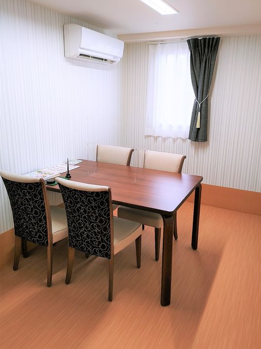 エアコンと窓のある一角に四人掛けのテーブルが置かれた部屋