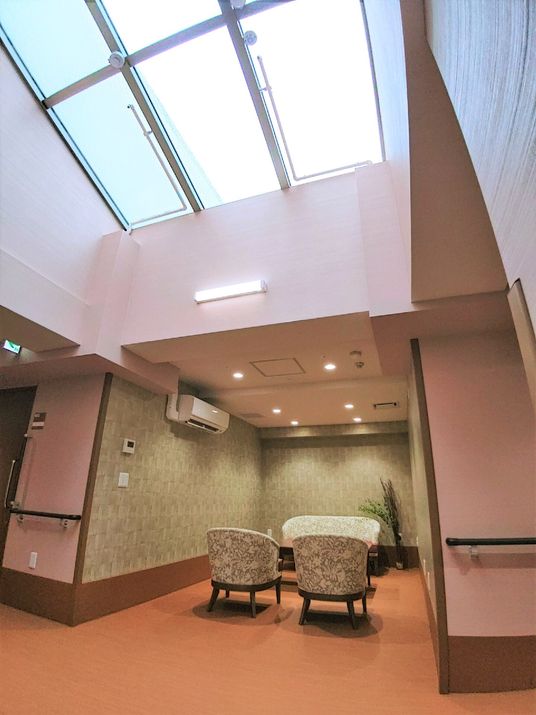 高い天井に天窓を設けた空間に、ソファーセットを置いた共有スペース