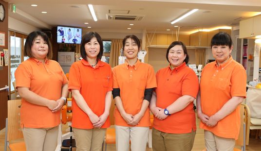 笑顔のスタッフが立つ室内