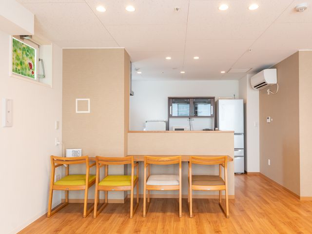 居室内の明るいダイニング キッチン 明るく開放的なダイニングスペースです。清潔な木製の椅子が並び、快適に食事ができる環境が整っています。