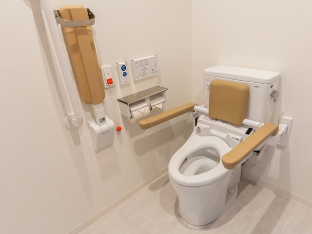 バリアフリー設計のトイレ トイレ さまざまなニーズに応えるために工夫が凝らされたトイレです。手すりや座面の高さ調整などが可能で、快適にご利用いただけます。