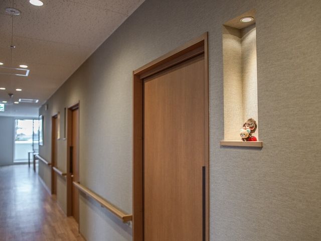 廊下と装飾の人形 廊下 暖かみのあるデザインの廊下です。壁のニッチに飾られた人形が、訪れる人々にほっこりとした気持ちを与えます。