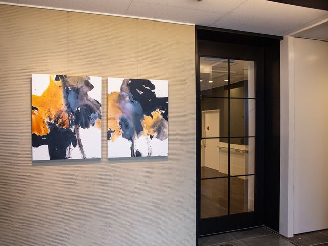 モダンな廊下の壁画 内観 モダンなデザインの壁画が設置された廊下は、洗練された空間を提供します。清潔感のある透明なガラス扉が印象的です。