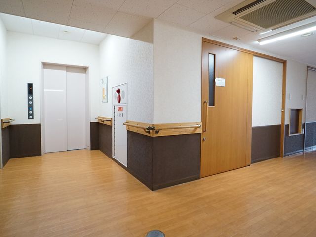 廊下と扉の明るい空間 廊下 広々とした廊下はバリアフリー設計になっており、どの部屋へも安心してアクセスできます。木目調の扉が温かみのある雰囲気を醸し出しています。