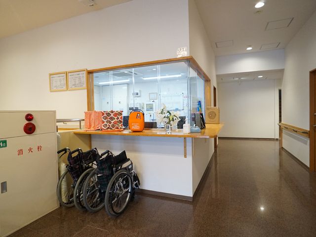 受付と車椅子がある廊下 エントランス 親切な対応を心掛けている清潔な受付エリアです。通路は広々としていて、車椅子でも安心してお過ごしいただけます。