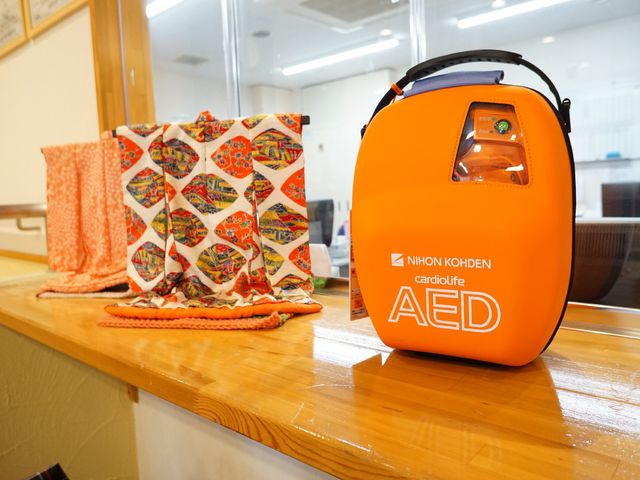 AEDと布製品が置かれたカウンター AED 応急処置用のAEDが常備され、緊急時にも素早い対応が可能です。カラフルな布製品も配され、温もりを感じられる空間です。