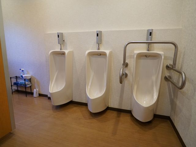 バリアフリー対応トイレ 男性用便器 手すりがついた使いやすいトイレです。車椅子の方も安心してご利用いただける設計となっています。